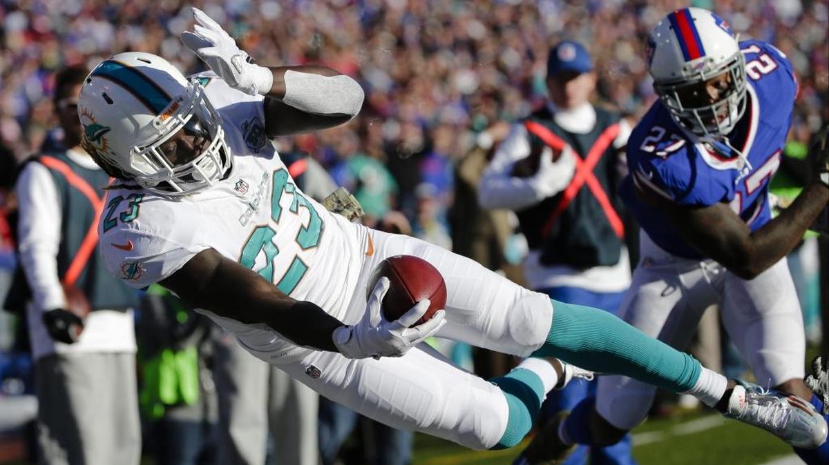 Miami Dolphins running back Jay Ajayi (23) dives past Buffalo Bills’ Duke Williams (27) during the second half of an NFL football game Sunday, Nov. 8, 2015, in Orchard Park, N.Y.