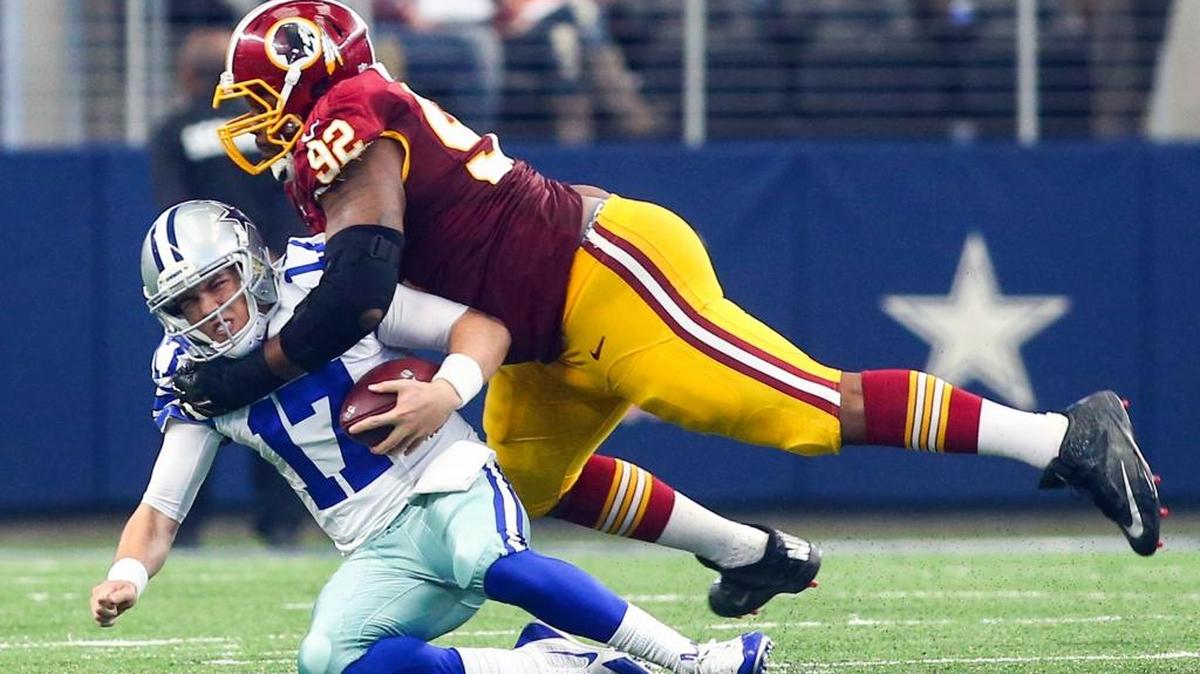 Cowboys quarterback Kellen Moore is sacked by Redskins defensive end Chris Baker during the third quarter Sunday in Arlington, Texas.