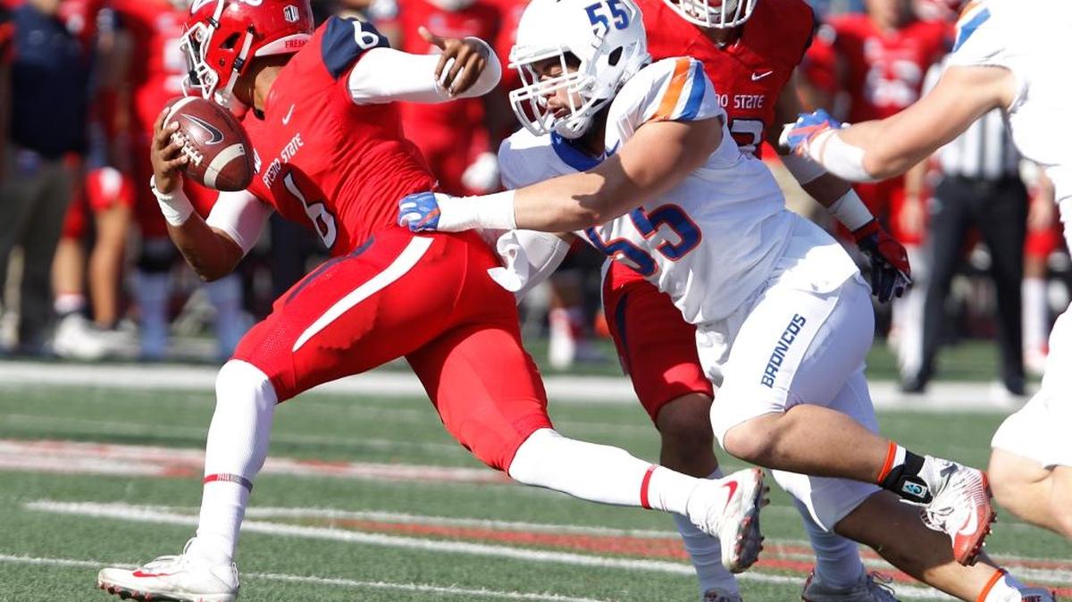 Fresno State quarterback Marcus McMaryion is grabbed by Boise State defensive tackle David Moa during the first half Saturday in Fresno, California.