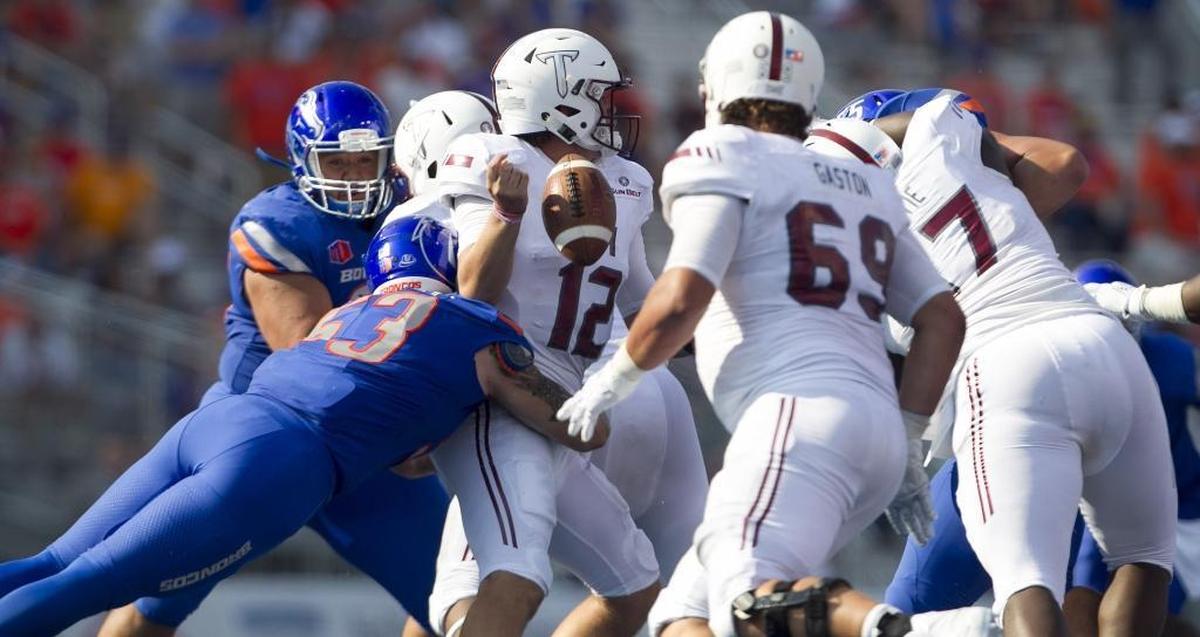 Boise State defensive end Sam Whitney (53) hits Troy quarterback Brandon Silvers (12) to force a fumble recovered by the Broncos during the season opener Saturday. The Broncos forced three turnovers.