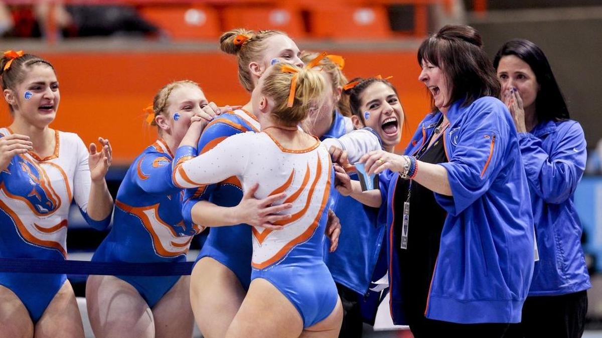 The Boise State gymnastics team celebrates with teammate Krystine Jacobsen (back to camera) after her floor routine wrapped up the win for the No. 15 Broncos during the Mountain Rim Gymnastics Conference championships Saturday at Taco Bell Arena.