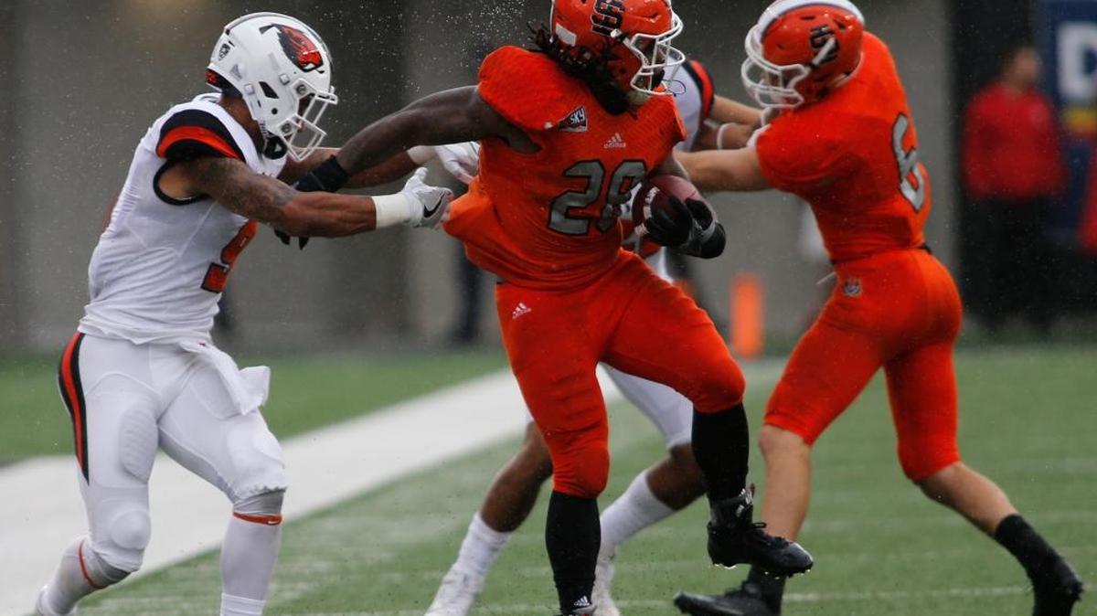 Idaho State running back Jakori Ford, center, spins away from Oregon State's Devin Chappell, left, during the first half of an NCAA college football game in Corvallis, Ore., on Saturday Sept. 17, 2016.