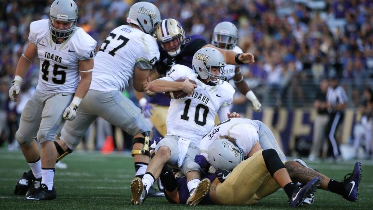Idaho quarterback Matt Linehan, center, is sacked by Washington linebacker Psalm Wooching during the first half Saturday in Seattle. The Huskies had four sacks and three takeaways.