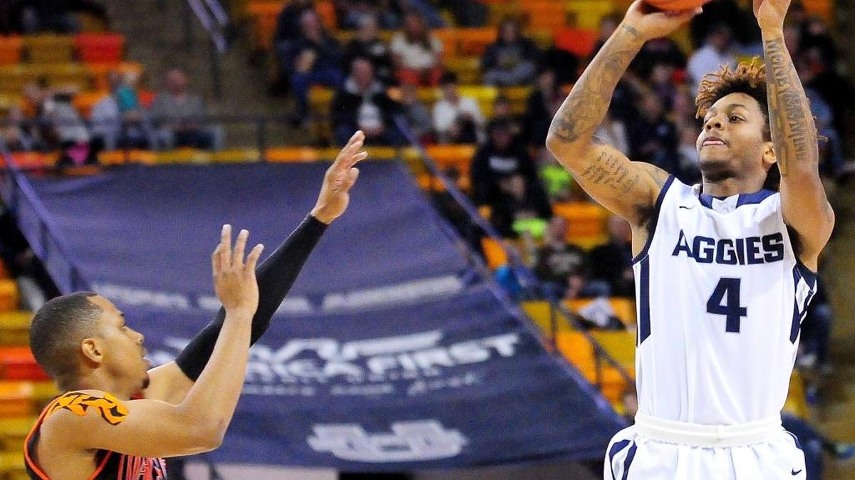 Utah State’s Shane Rector shoots over Idaho State’s Ethan Telfair during an NCAA college basketball game Tuesday, Dec. 22, 2015, in Logan, Utah.