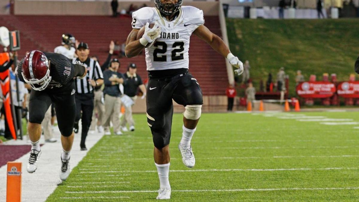 Idaho running back Elijhaa Penny sprints to the end zone ahead of New Mexico State linebacker Dalton Herrington during their game in Las Cruces, N.M., on Saturday, Oct. 31, 2015.