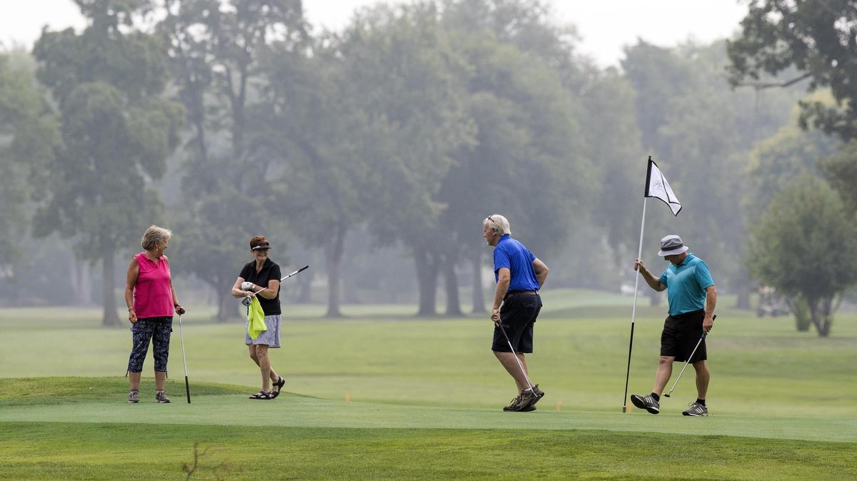 From left: Brenda Malone, Laura Riecker, Jerry Lyle and Keith Huck play a round of golf in the smoky air at Plantation Country Club in Garden City on Wednesday.