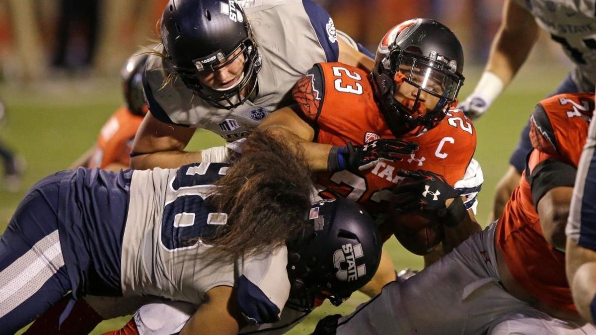 Utah State defensive end Edmund Faimalo (98) tackles Utah running back Devontae Booker (23) during the second half of their game Sept. 11 in Salt Lake City.