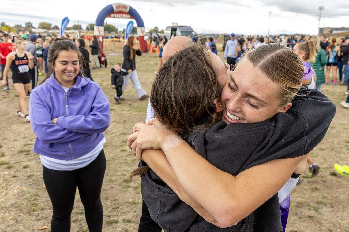 Rocky Mountain’s Hallie Heemeyer embraces Rocky Mountain coach Amber Clintsman after winning the 6A girls race Saturday at the Idaho state cross country championship at Community Park in the Lewiston Orchards.