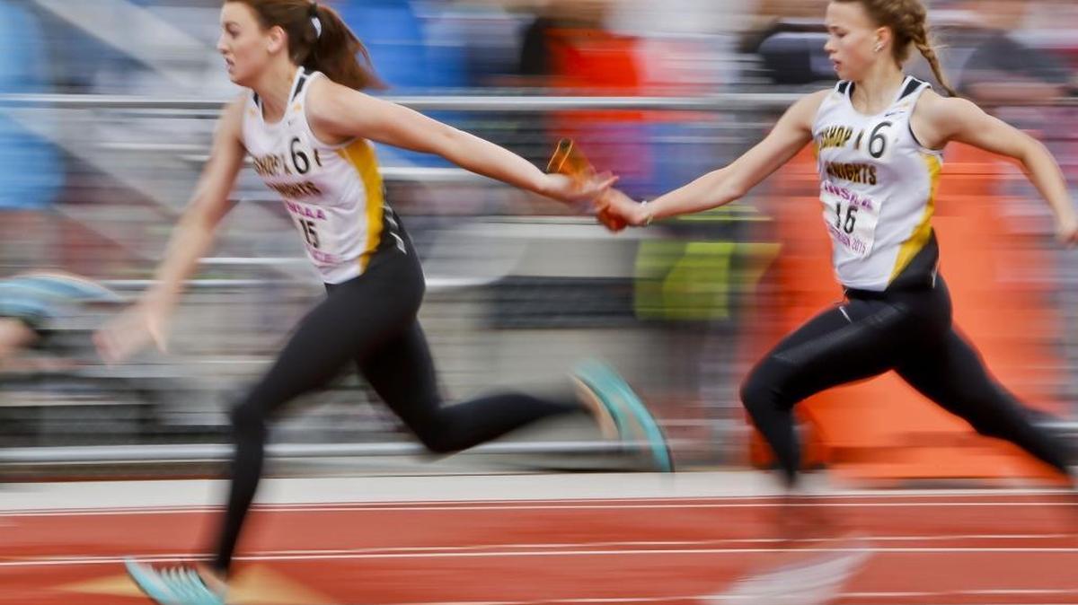 Bishop Kelly junior Payton Kirtley, right, hands off to senior Payton Jolley at last year’s 4A state track and field meet at Dona Larsen Park in Boise. The Knights won the girls team title.