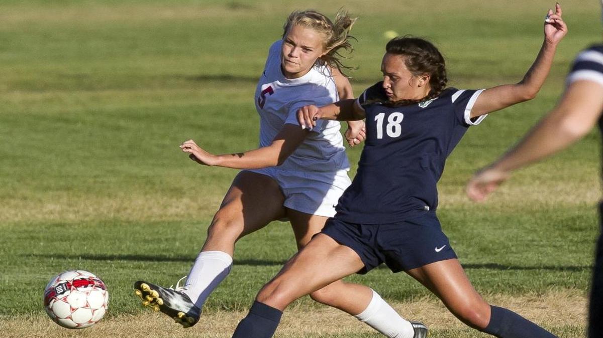 Mountain View midfielder Hailey Hill (18) fights for possession of the ball with Centennial defender Sasha DeVille (5) during a game on the Patriots’ home pitch Oct. 3, 2016.