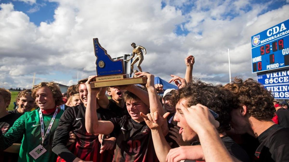 The Boise High boys soccer team celebrates with its 5A state championship trophy Saturday at Coeur d’Alene High.