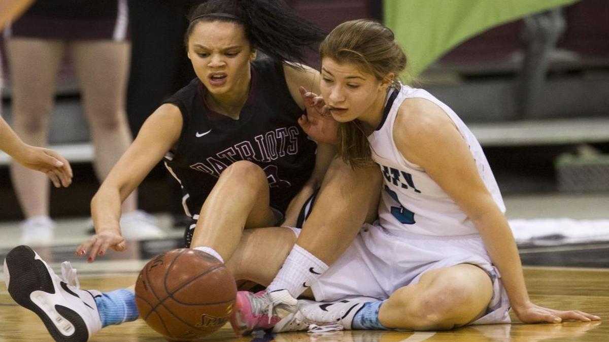 Centennial’s Tori Williams and Lake City’s Nina Carlson get tangled up going after the ball in the first round of the 5A girls state basketball tournament Feb. 18 at the Idaho Center.