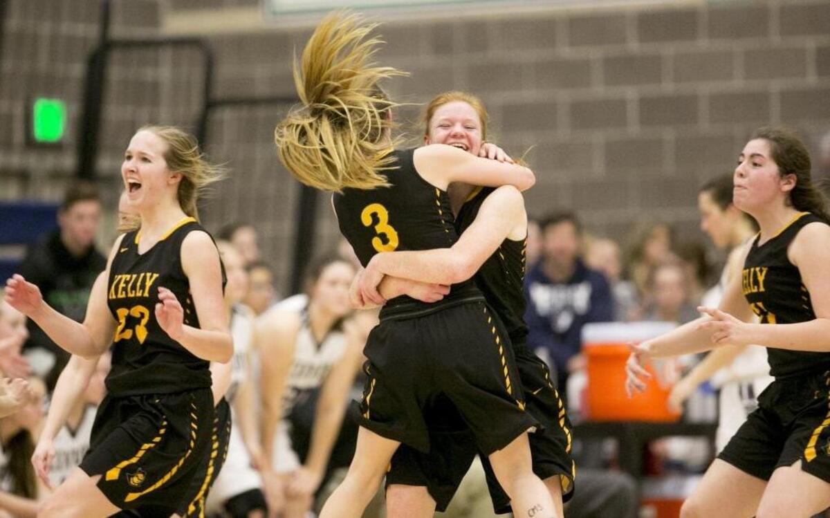 Bishop Kelly High’s Monica Behrend, facing, hugs teammate Olivia Kent (3) after the final buzzer sounded in a 56-49 victory over Century in the first round of the 4A girls basketball state tournament at Mountain View High.