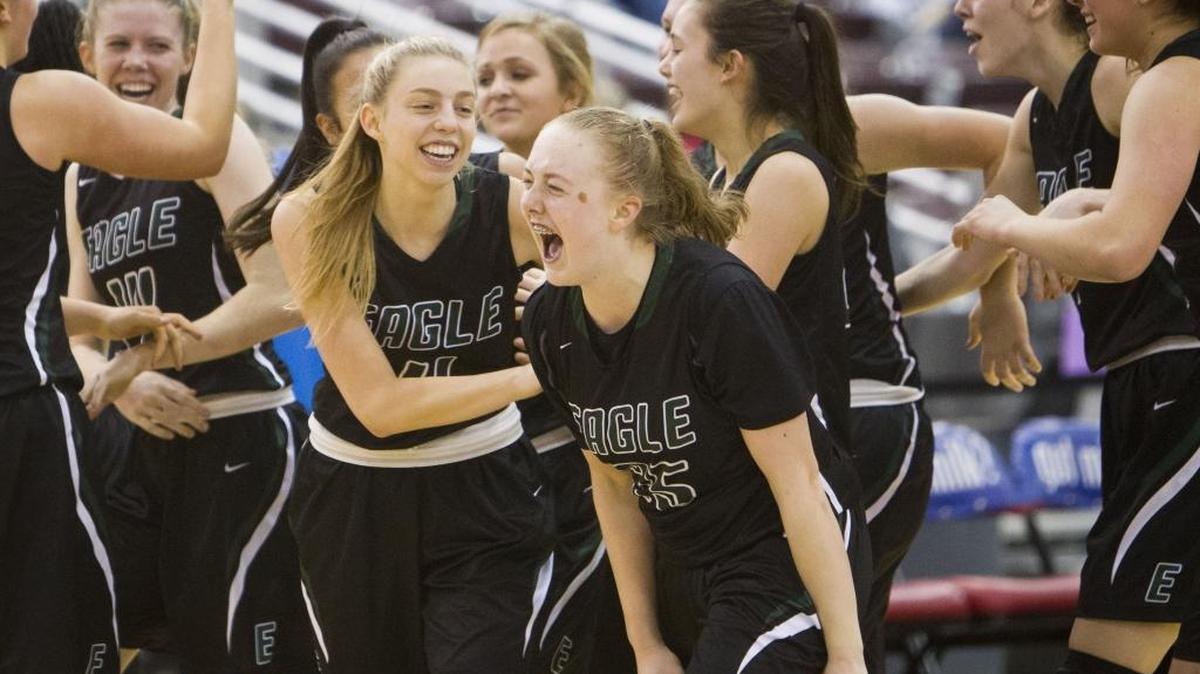 Meghan Boyd (25) and Janie King (11) celebrated Eagle’s 57-54 victory over Post Falls in the semifinal game of the 5A state tournament Friday at the Ford Idaho Center.