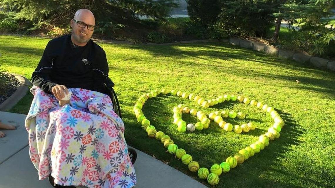 Former Eagle softball coach Doug Corta poses with an arrangement of softballs former players left on his lawn on Oct. 11