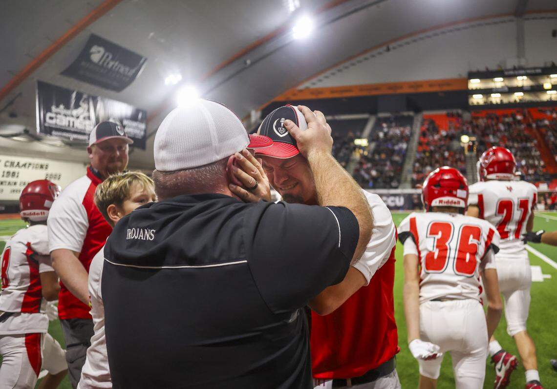 Homedale coach Matt Holtry, center, bursts into tears and shares a moment with his brother, Dan Holtry, after winning a long-awaited 4A state championship Saturday. 
