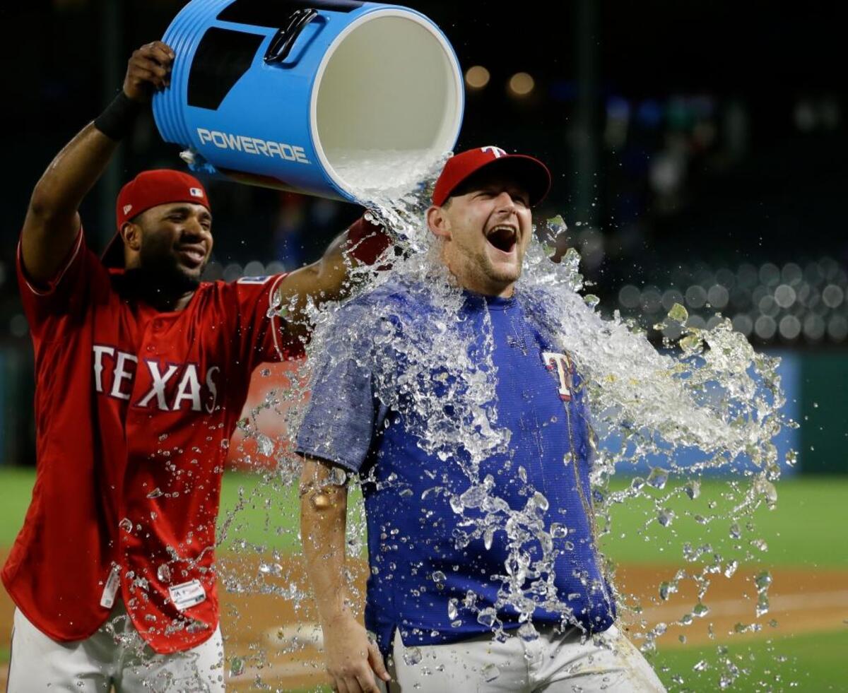 Meridian resident Austin Bibens-Dirkx receives a postgame bath from Elvis Andrus after the Rangers’ 9-8 win over the White Sox in August.