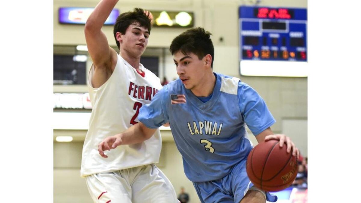 Lapwai’s Emmitt Taylor drives toward the basket along the baseline as Ferris’ Shamrock Campbell defends on the play during the second quarter of the championship game of the Avista Holiday Tournament.