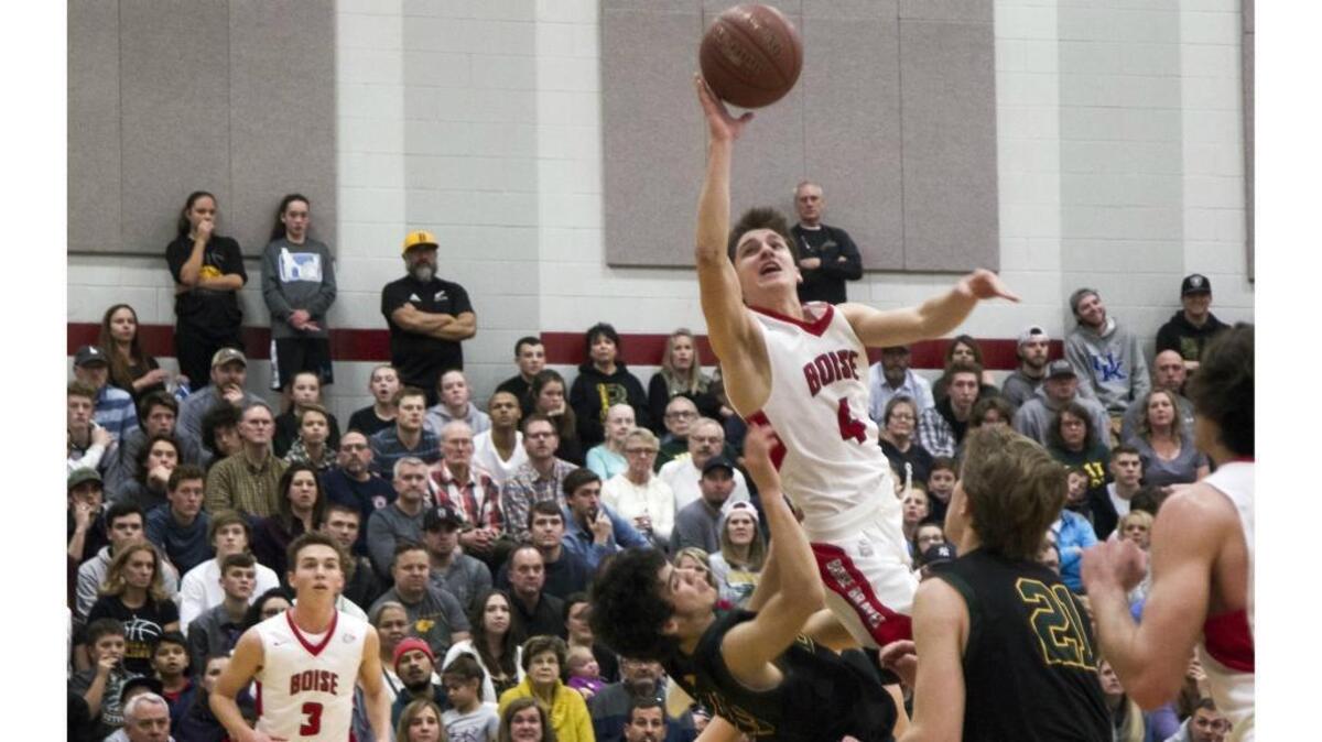 Boise guard Paul Pennington leaps over the top of Borah’s Kyler Castro, scoring and drawing a foul Jan. 20 at Boise High.