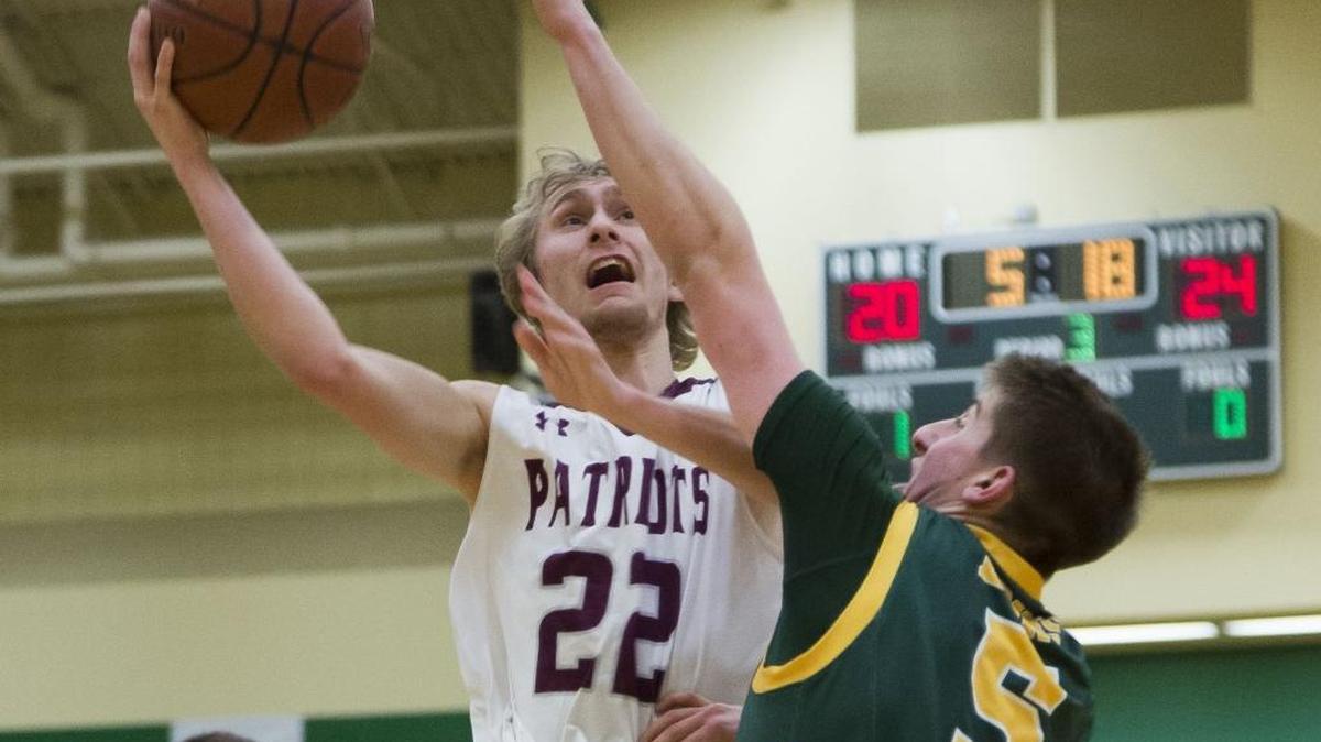 Centennial’s Taylor Wallick navigates around Borah’s Max Reitman for a shot in the 5A District Three boys basketball championship Feb. 26 at Borah High.