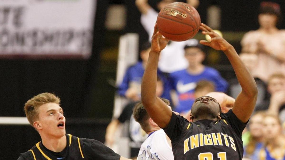Bishop Kelly’s Raoul Johnson grabs a rebound in the state championship game last year against Preston at the Ford Idaho Center.