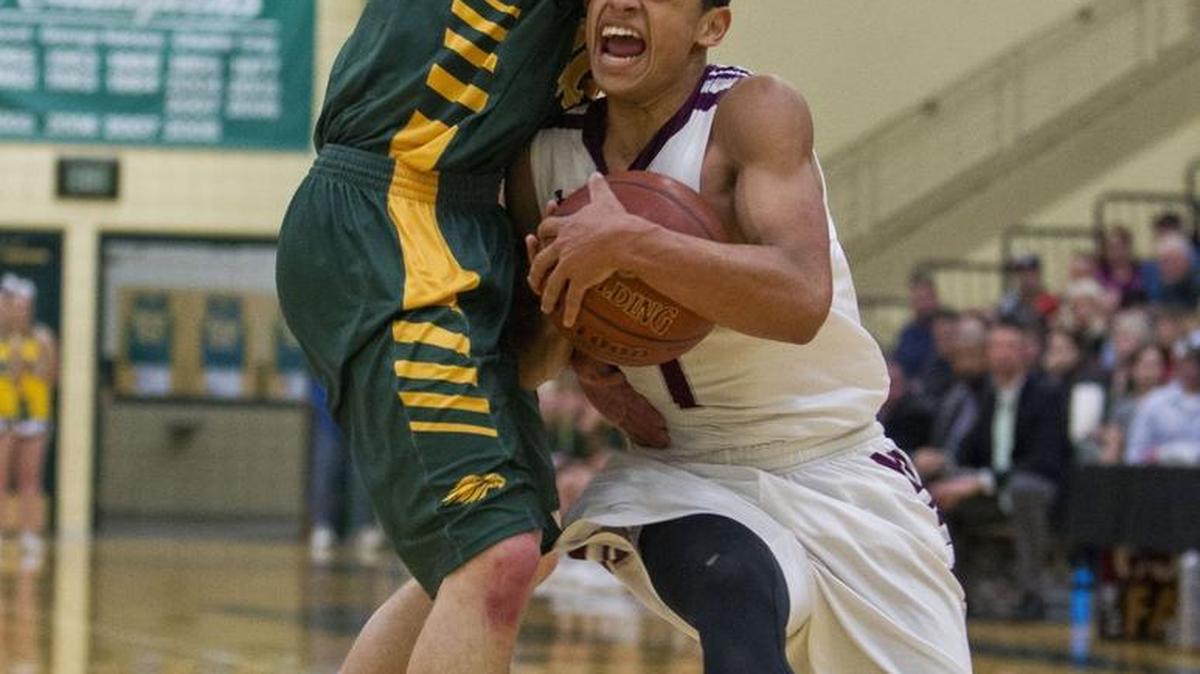 Borah’s Talon Pinckey goes up against a Centennial defender in the 5A District Three boys basketball championship Feb. 26 at Borah High. The Lions defeated the Patriots 43-32.
