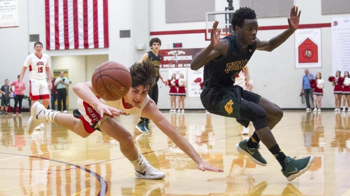 Boise junior Emmett Plummer, left, and Borah’s DeVaughn Williams chase a loose ball Saturday at Boise High.