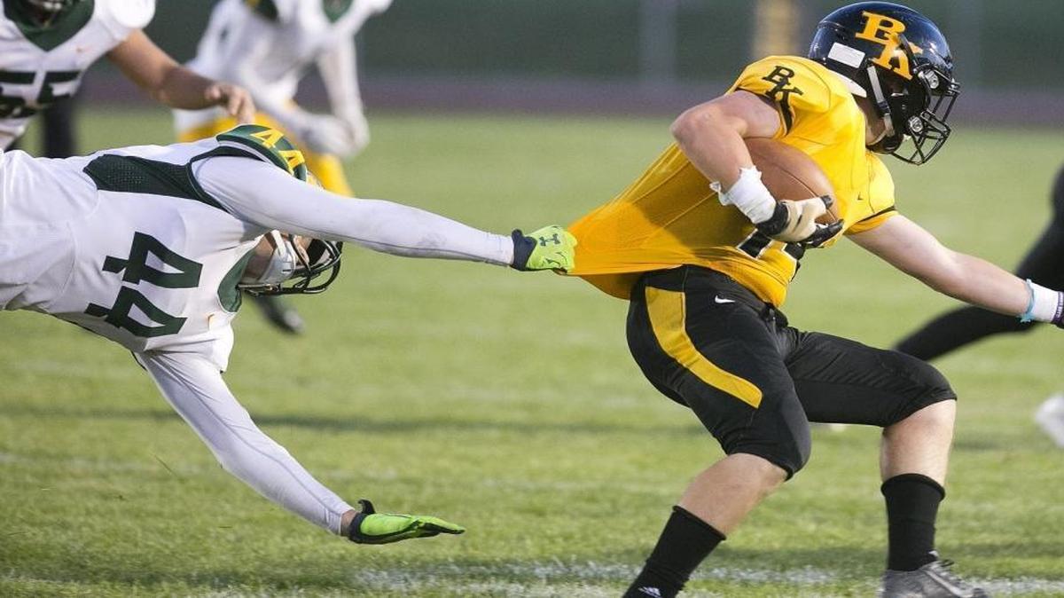 Borah linebacker George Tarlas, left, stretches out for a tackle against Bishop Kelly on Sept. 2.