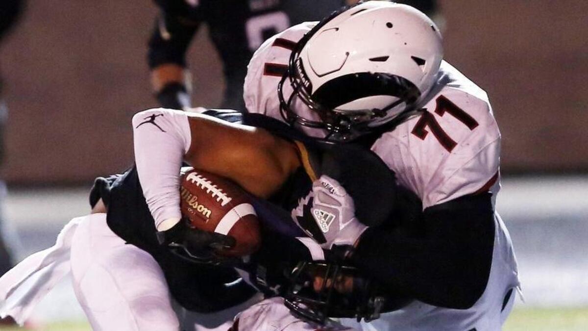 Highland’s Tommy Togiai (71) and Spencer McSpadden stop Rocky Mountain’s Duanavan Jardine behind the line of scrimmage in the second half a 5A state semifinals Nov. 10.