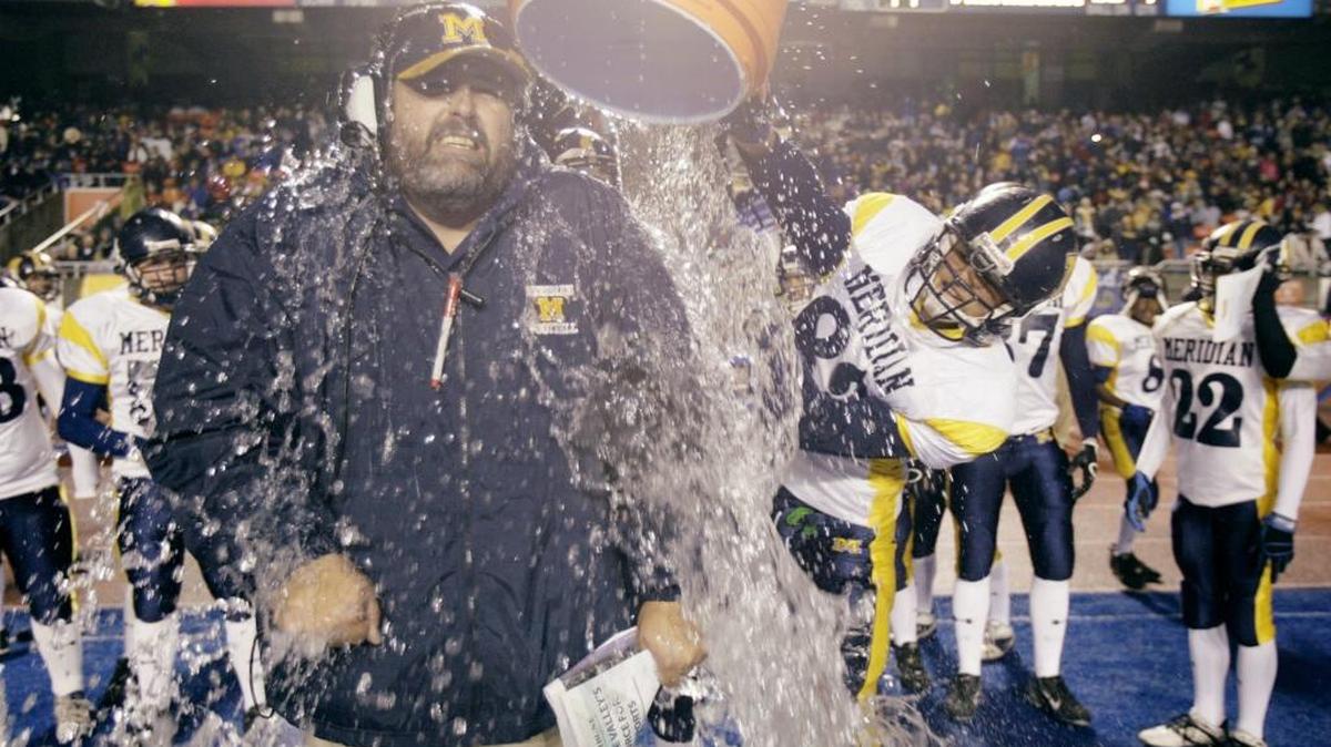 Former Meridian coach Kip Crofts gets a bucket of ice water poured over him over the Warriors defeated Capital 45-14 for the 2007 state title at Albertsons Stadium.
