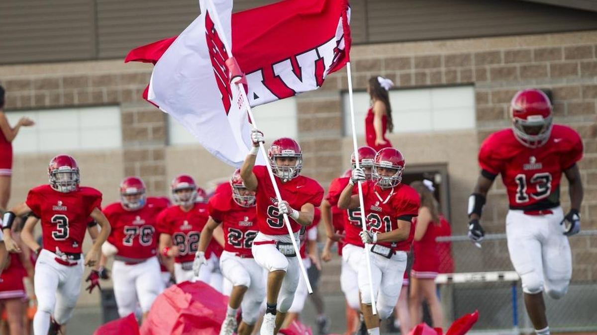 Boise High players Mateo Ozuna (21) and Mackay Fitzgerald (9) lead their team onto the field to face Ridgevue in the season opener Thursday at Dona Larsen Park. Ridgevue won 14-10.