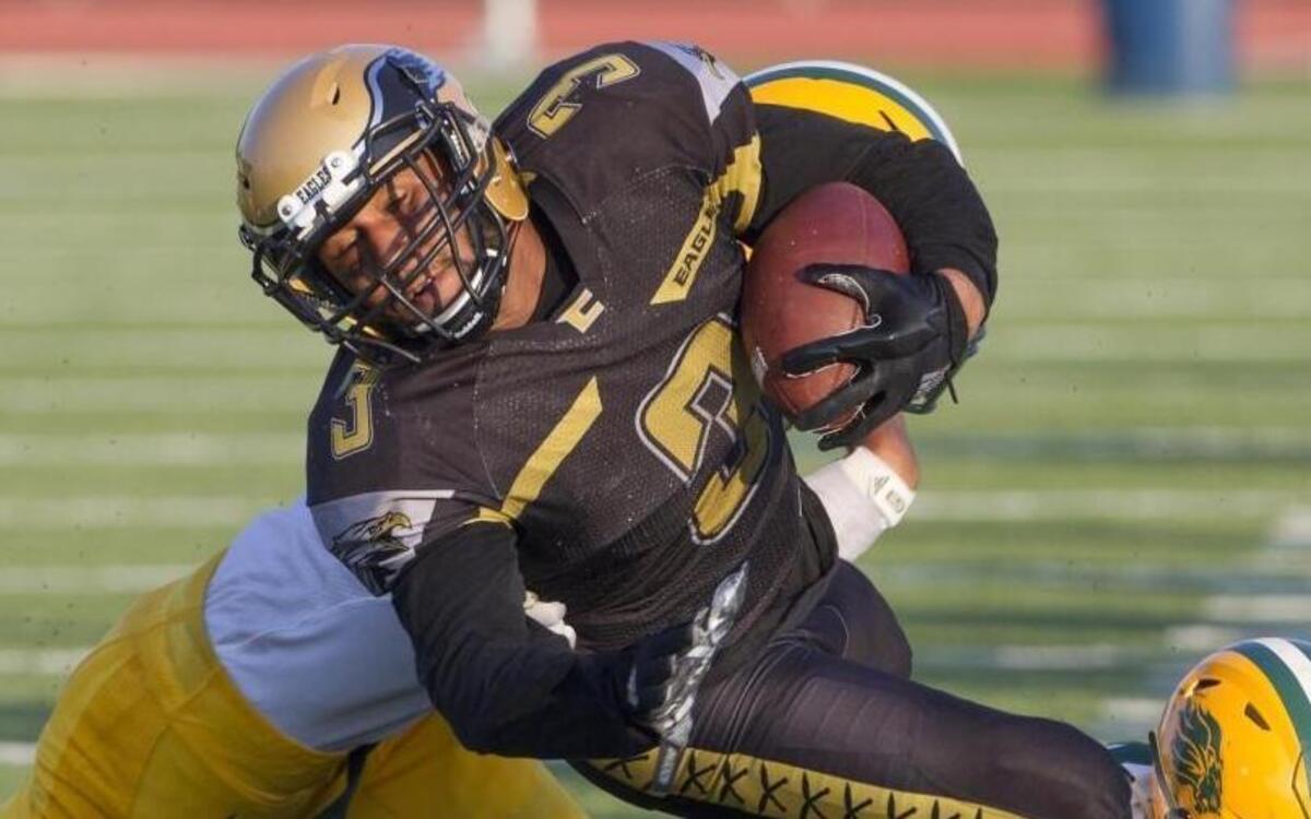 Capital wide receiver Jordan Godeny-Scott fights for extra yardage on a reception before being tackled at the sideline by Borah’s Cory Lewis, right, and Ilaisa Makaafi.