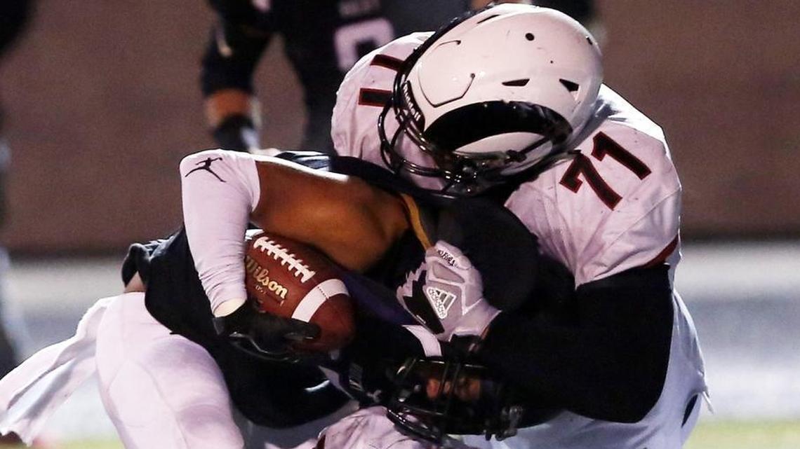 Highland’s Tommy Togiai and Spencer McSpadden stop Rocky Mountain’s Duanavan Jardine behind the line of scrimmage Friday in the 5A state semifinals at Rocky Mountain.