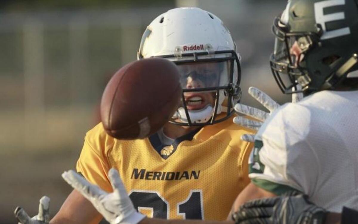 Eagle’s Brennan Larsen comes down with a catch under pressure from Meridian’s Bridger Mortensen.