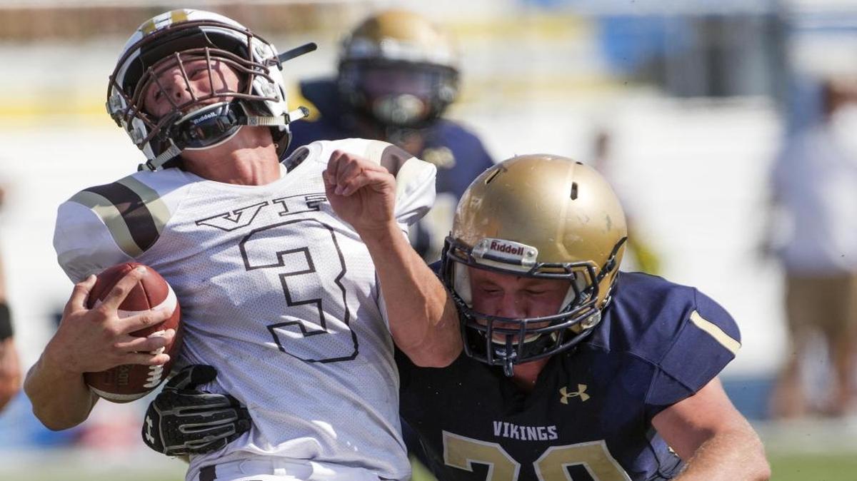 Middleton defensive lineman Sheridan White wraps up Vallivue quarterback Lan Larison on Saturday at Middleton High. The 4A SIC opener for both teams was postponed to Saturday because of poor air quality in the Treasure Valley.