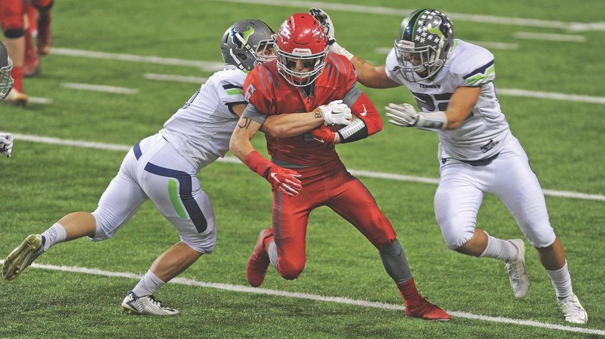 Mountain View defensive back Josh Elsberry, left, and linebacker Khalid Hardy sandwich Madison wide receiver Curtis Hathaway on Friday in the 5A state semifinals at Holt Arena in Pocatello.
