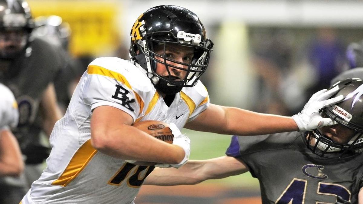 Bishop Kelly’s Ben Hruby stiff arms Century’s Adam Ping on his way to a big gain late in the second quarter Thursday in the 4A semifinals at Pocatello’s Holt Arena.