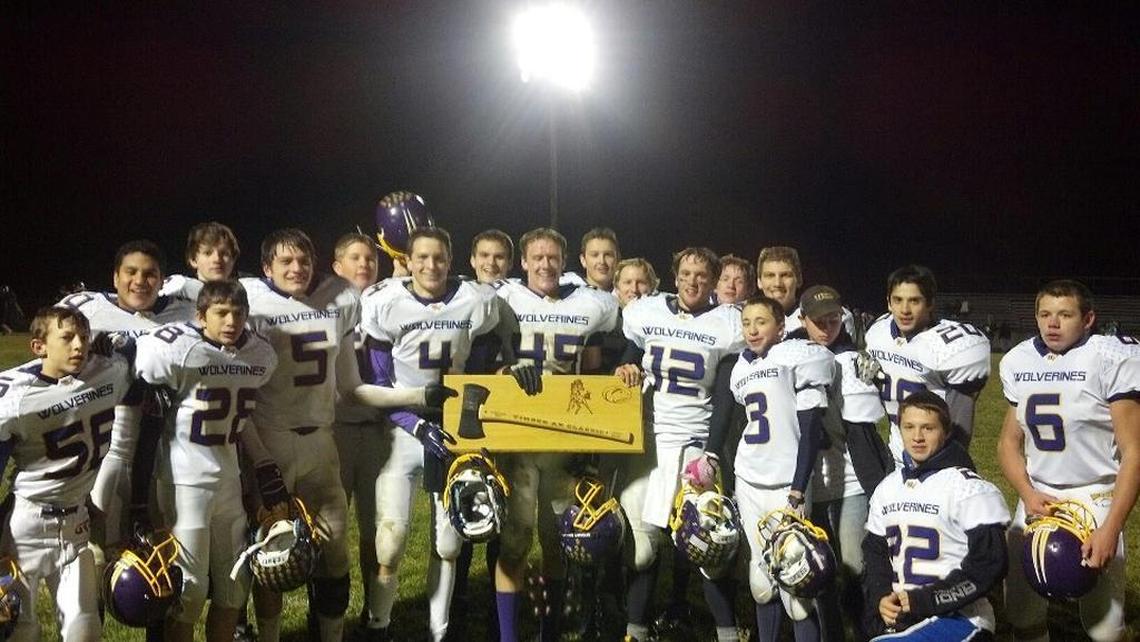 The Garden Valley football team poses with a double-sided ax awarded to the winner of the Timber Ax Classic between the Wolverines and Horseshoe Bend.
