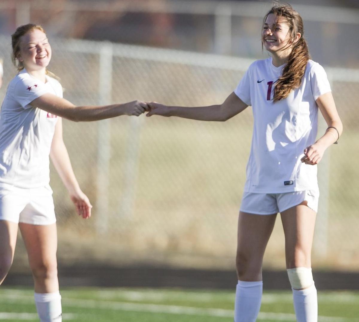 Centennial’s Grace Pekovich, right, slaps hands with teammate Aanika Stevens during the first round of the 5A girls soccer state tournament Thursday at Meridian High.