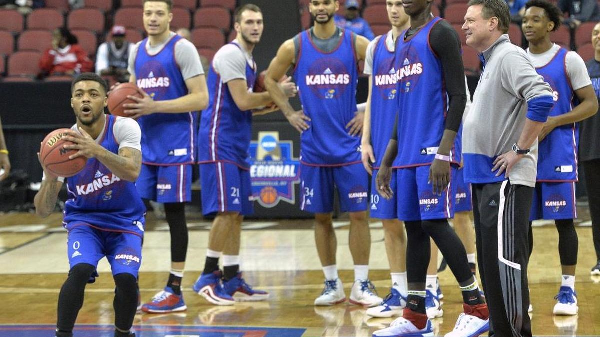 Kansas guard Frank Mason III attempts a half court shot as head coach Bill Self and teammates watch during Wednesday’s practice session in Louisville, Ky.
