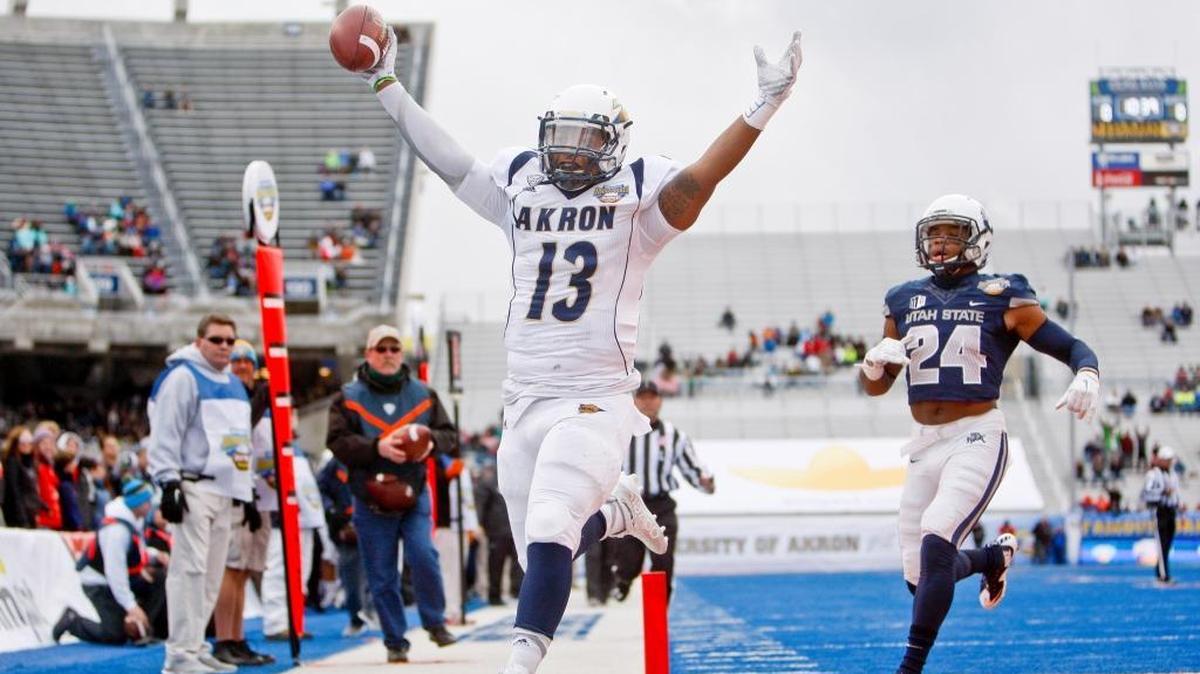 Akron quarterback Thomas Woodson (13) runs in for a touchdown while being pursued by Utah State safety Marwin Evans (24) during the first half of the Famous Idaho Potato Bowl held at Albertsons Stadium in Boise, Idaho. Akron led Utah State 13-7 at the half. Tuesday December 22, 2015