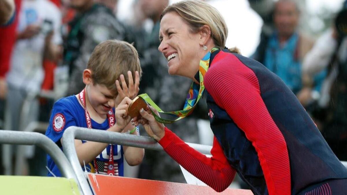 Boise’s Kristin Armstrong shows her gold medal to his son Lucas William Savola after winning the women’s individual time trial at the 2016 Summer Olympics in Rio.