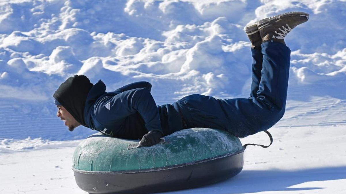 Akron football player Travonte Junius, a freshman defensive end/linebacker from Ohio, slides down the tubing hill at Bogus Basin outside Boise on Sunday.