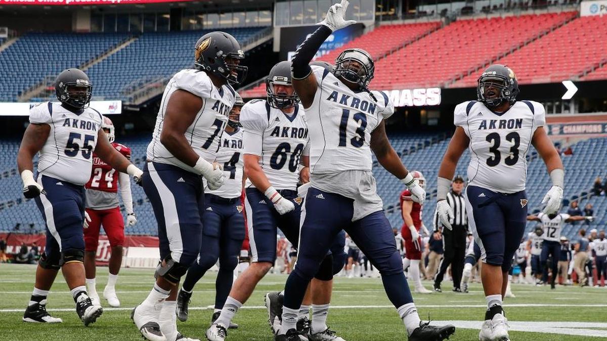 Akron quarterback Thomas Woodson (13) celebrates his touchdown with teammates during the third quarter of a college football game against Massachusetts in Foxborough, Mass., on Saturday, Nov. 7, 2015. Akron won 17-13.