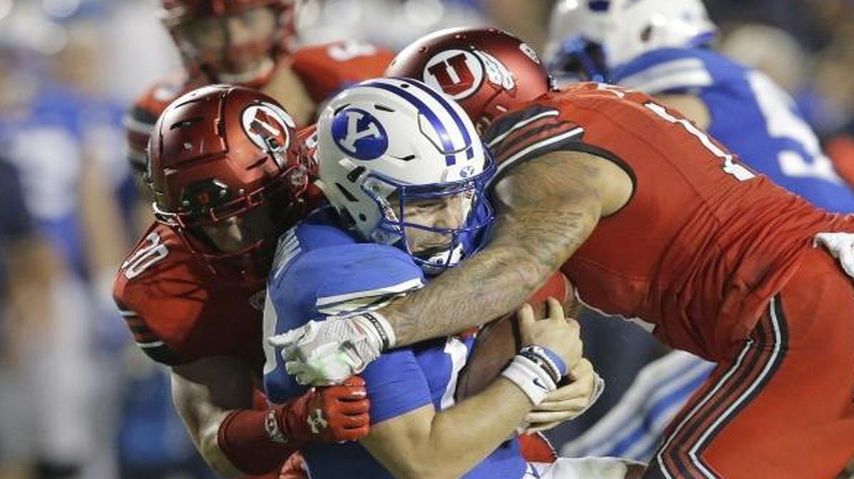 BYU quarterback Tanner Mangum, center, was sacked three times in a 19-13 loss to Utah. Mangum, an Eagle High graduate, completed 21 of 39 passes for 170 yards, one touchdown and three interceptions.