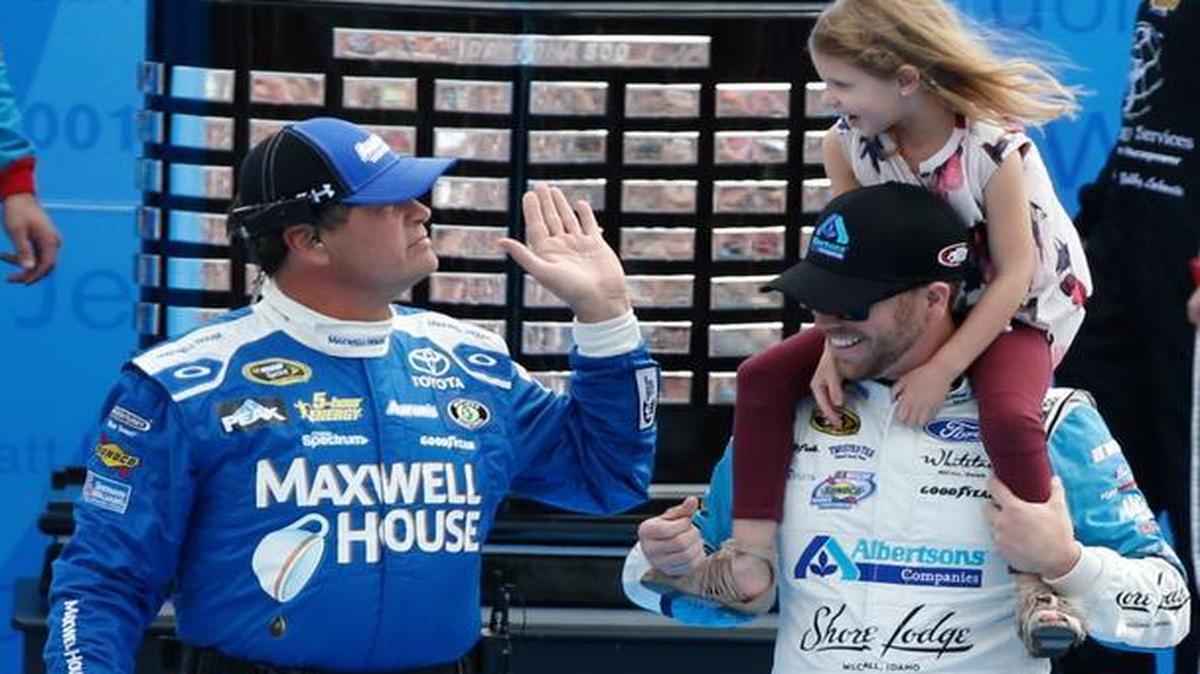 Michael Waltrip, left, waves to Brian Scott’s daughter as they are introduced Daytona 500 at Daytona International Speedway on Sunday in Daytona Beach, Fla.